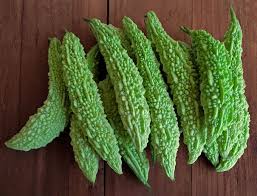 Green okra leaves on a wooden surface
