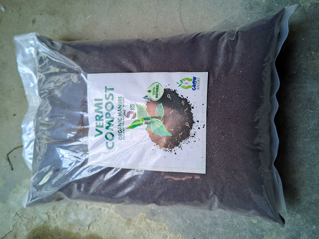 A large clear plastic bag filled with dark brown vermi compost manure, featuring a white label with green and black text and a small green leaf logo, placed on a concrete floor.